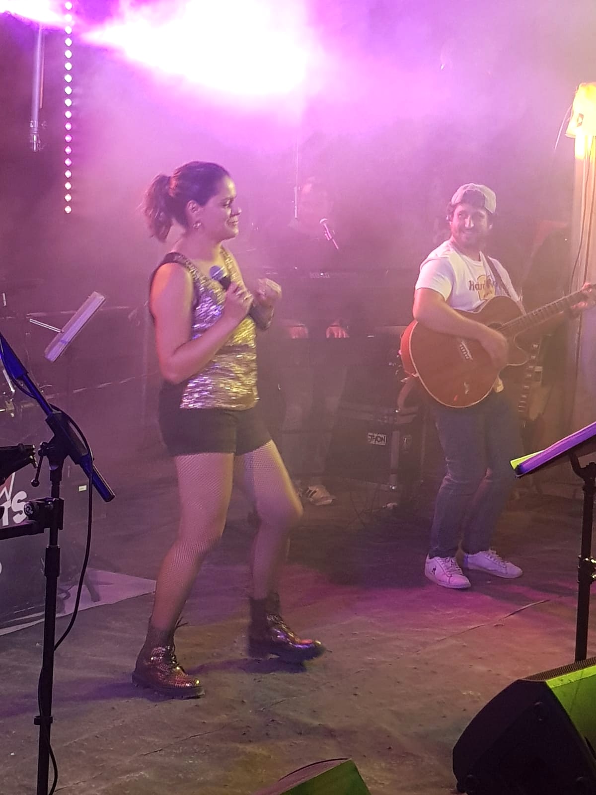 Une chanteuse de Watts Up en concert, lumières roses
