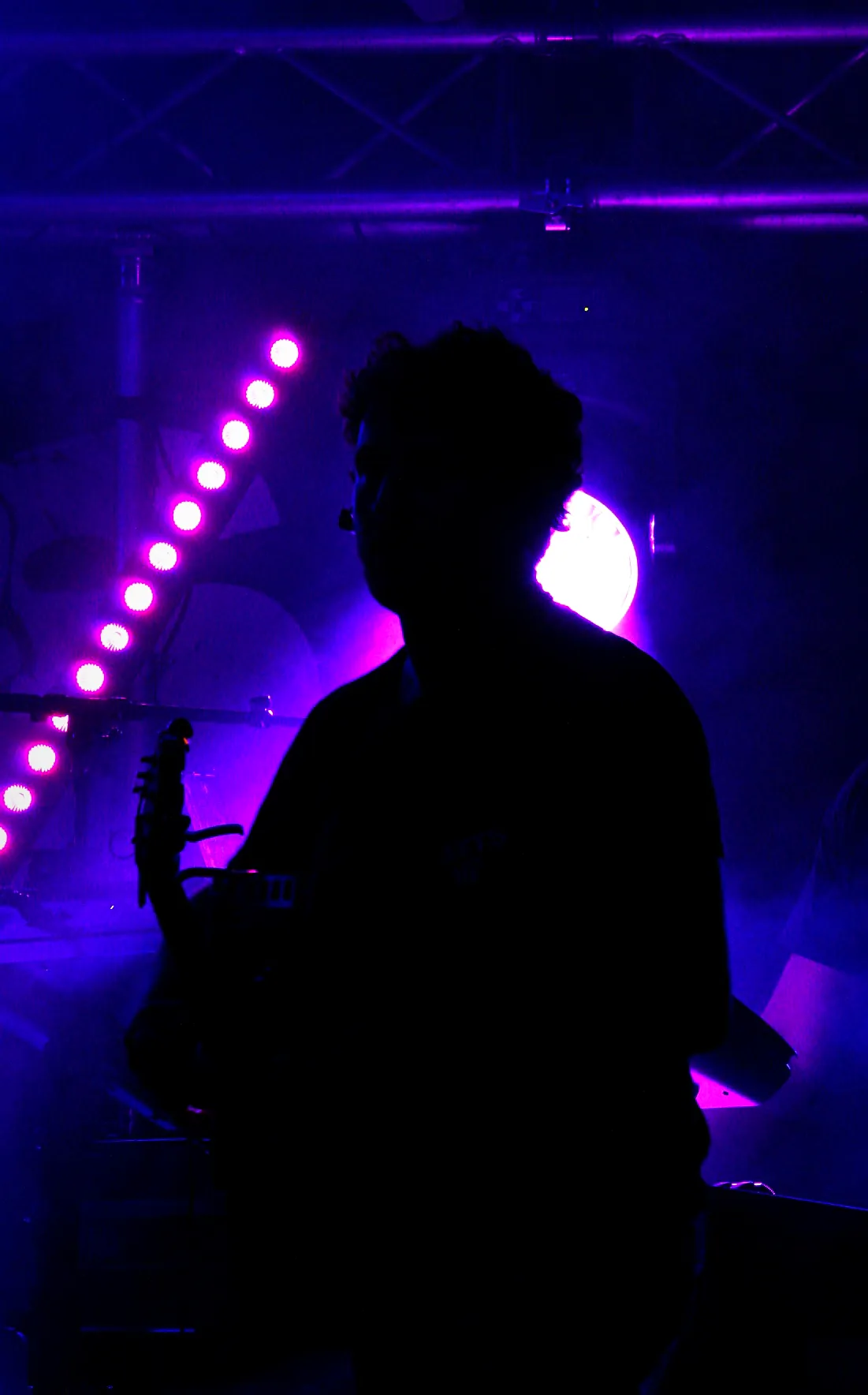 Le bassiste de Watts Up en silhouette devant les projecteurs roses