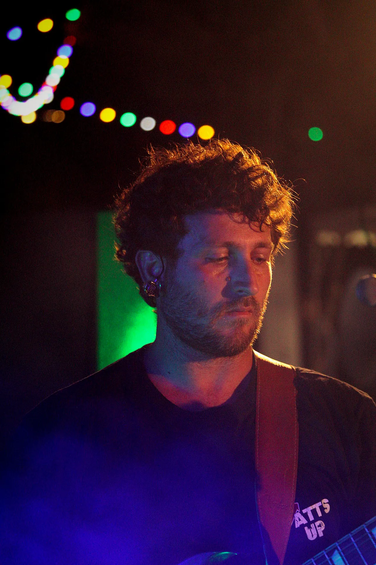 Guitariste de Watts Up, t-shirt du groupe, sous les lumières des 40 ans de Lous Esquiros