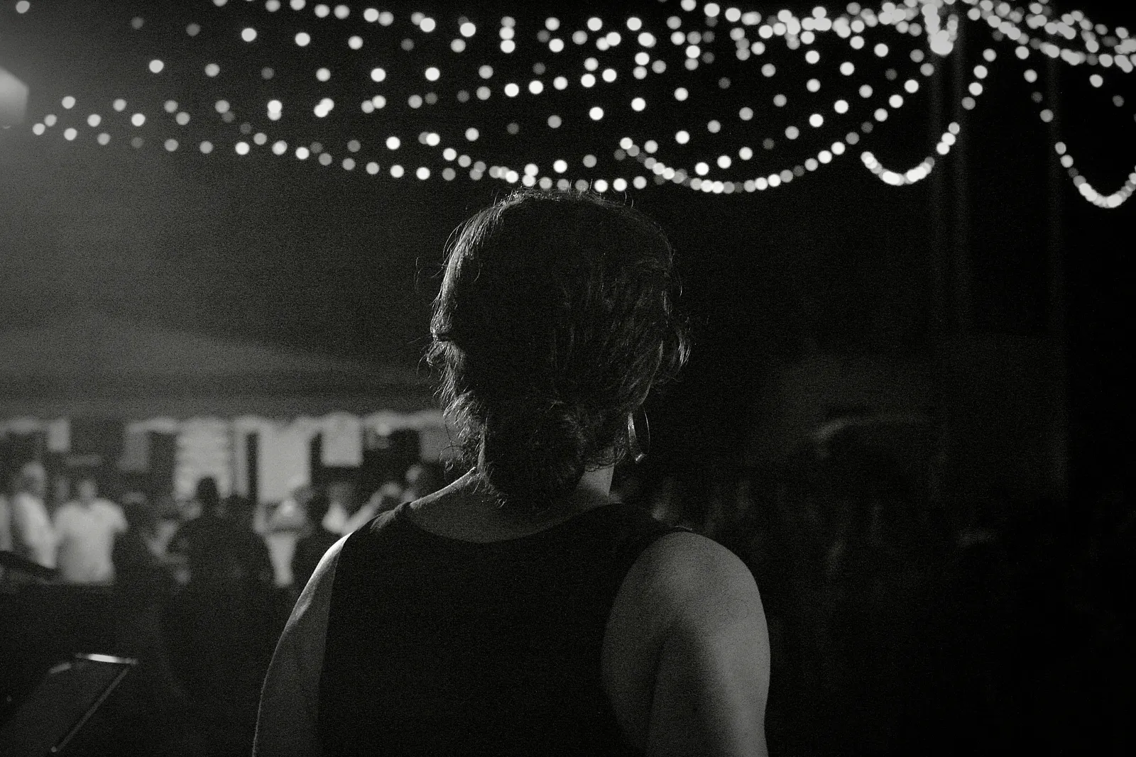 Vue depuis la scène : le public des 40 ans de Lous Esquiros à Saint-Vincent-de-Tyrosse, sous les guirlandes lumineuses, en noir et blanc