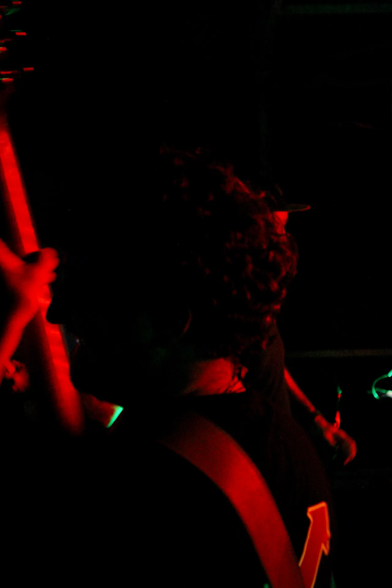 Chanteur de Watts Up au micro dans une ambiance rouge intense