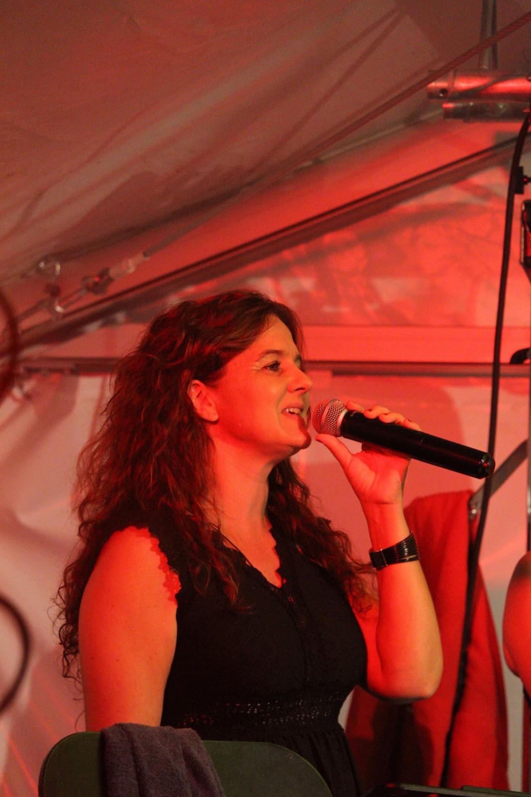 Une chanteuse de Watts Up sous les lumières rouges