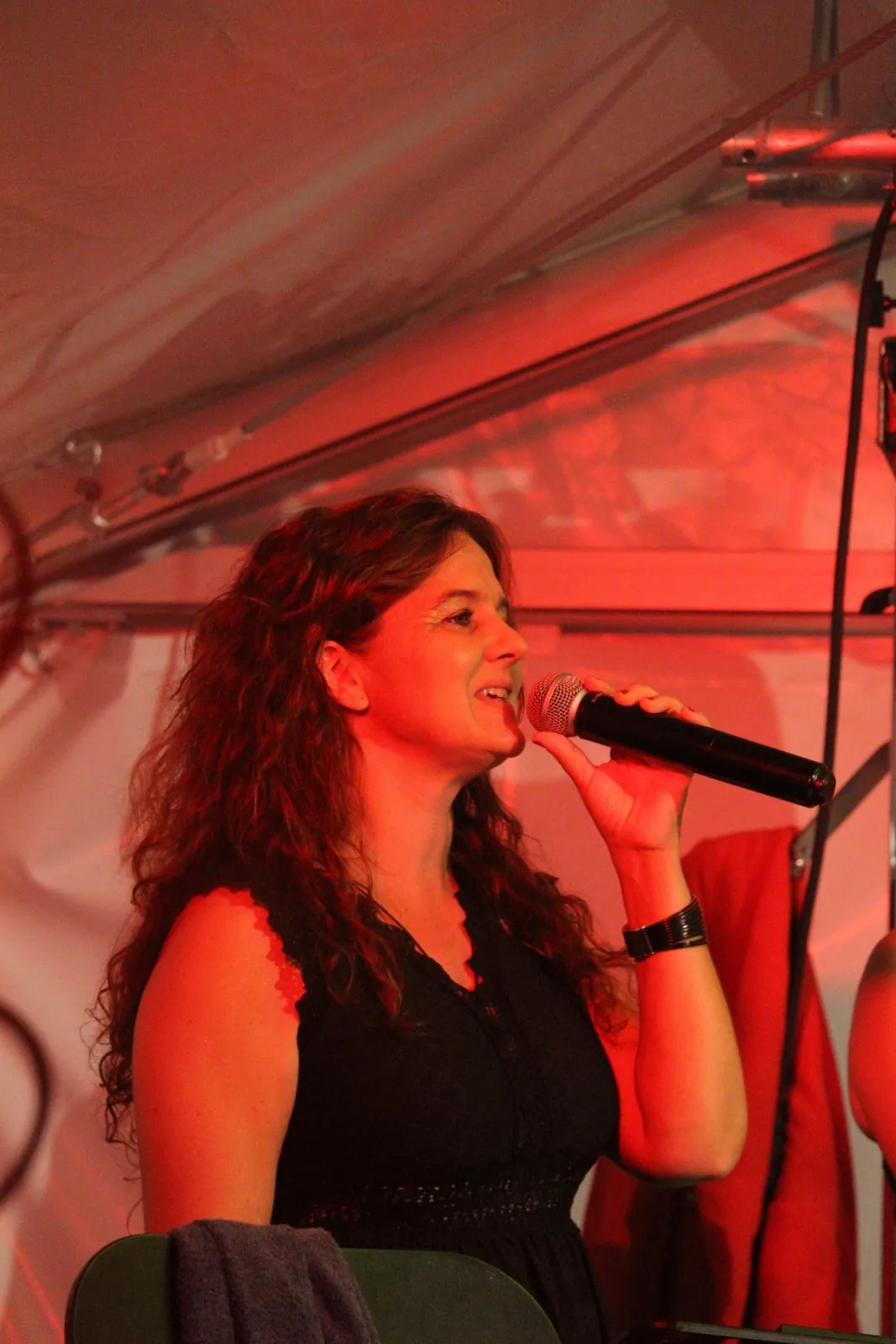 Une chanteuse de Watts Up sous les lumières rouges